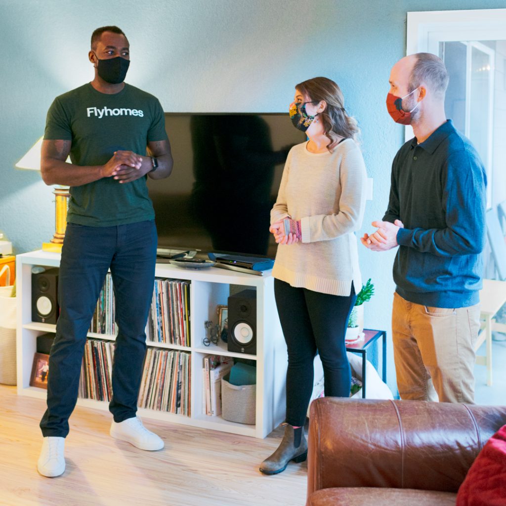 A Flyhomes real estate agent showing a home to a couple in their early thirties