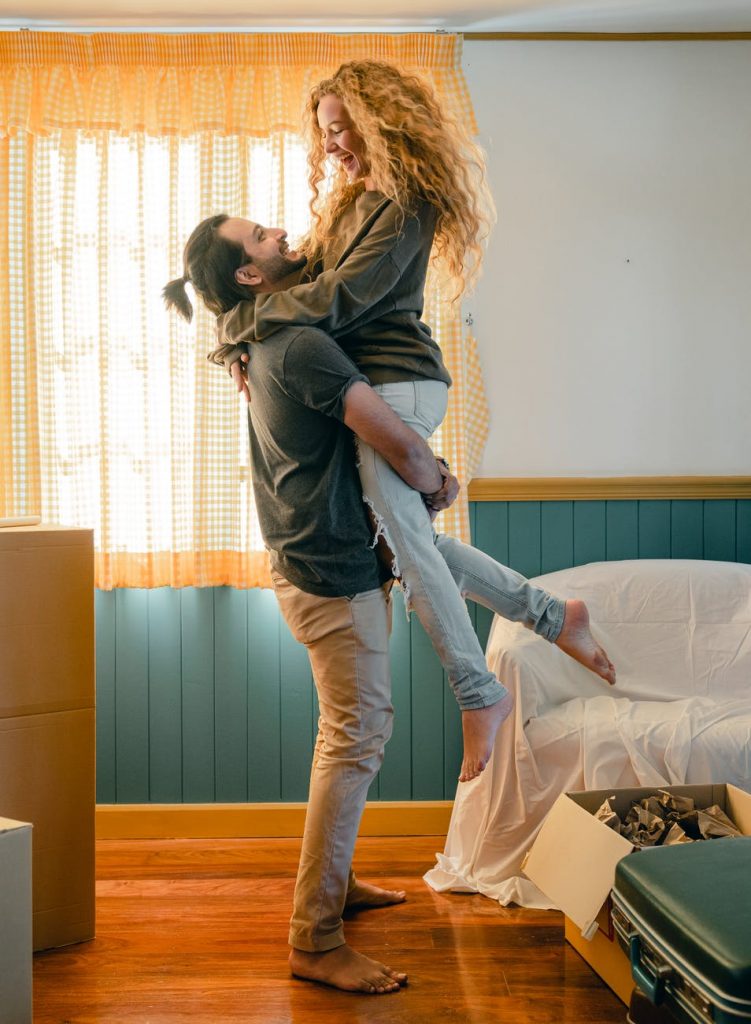 cheerful boyfriend lifting girlfriend up