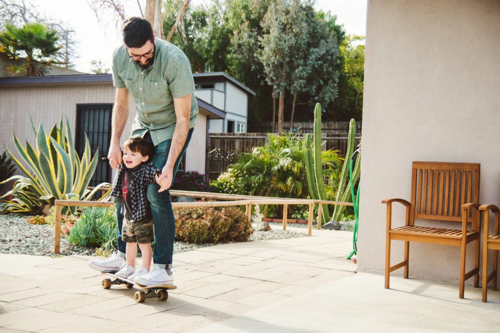 Man helping boy on skateboard