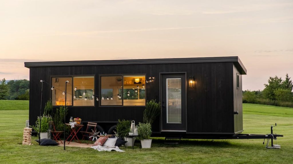 a tiny home in a field at sunset