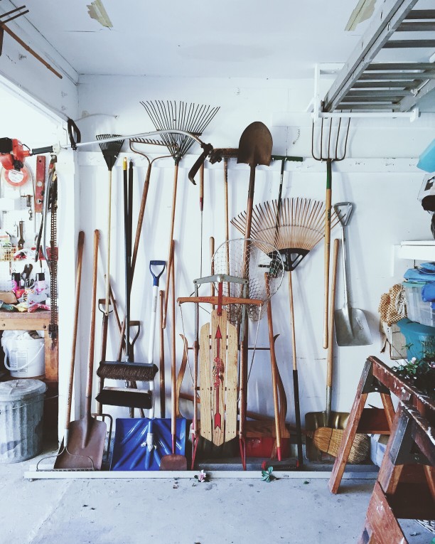 garage with rakes, shovels, sled, and tools
