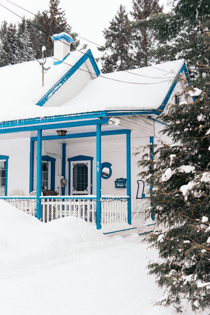 blue and white wooden house covered with snow