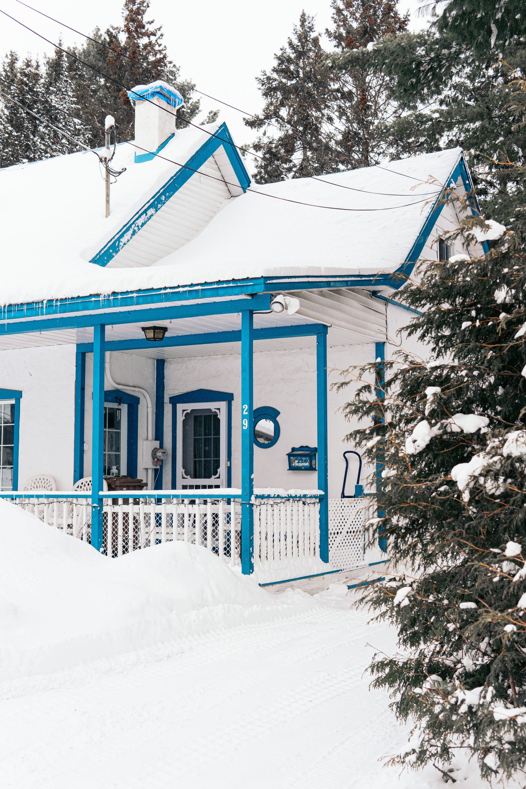 blue and white wooden house covered with snow