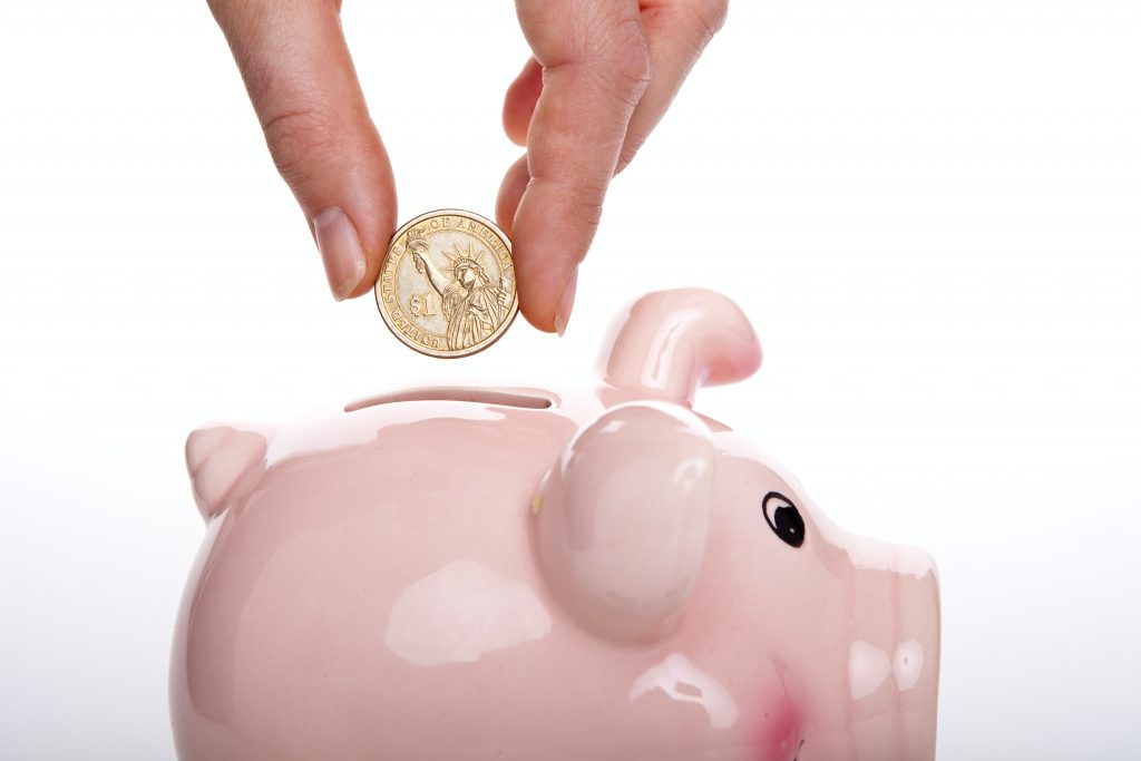 silver round coin on white ceramic pig coin bank