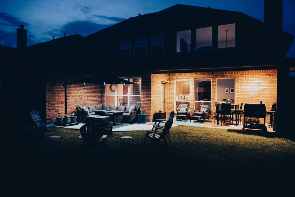 brown wooden table and chairs near brown concrete building during night time